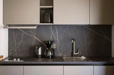 a kitchen counter with a sink and a coffee maker at Hotel & Residence Rebhof in Tirolo