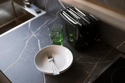 a white plate with a fork and a glass on a counter at Hotel & Residence Rebhof in Tirolo