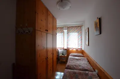 a bedroom with two beds and a window in it at Cá Enrosadira Piano Secondo in San Vito di Cadore