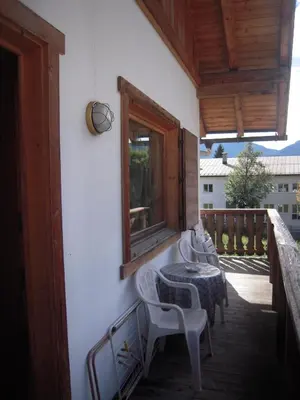 a balcony with a table and chairs and a window at Cá Enrosadira Piano Secondo in San Vito di Cadore