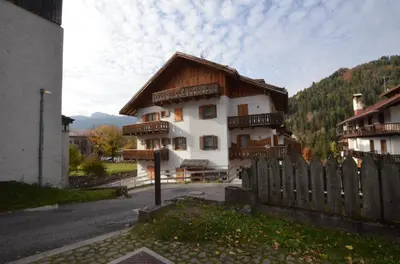 a large white house with a wooden fence at Cá Enrosadira Piano Secondo in San Vito di Cadore