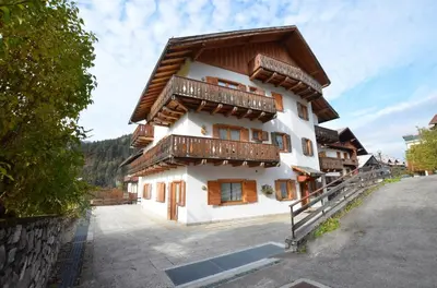 a house with wooden balconies on the side of it at Cá Enrosadira Piano Secondo in San Vito di Cadore