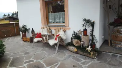 a porch with a bench with christmas decorations on it at Appartements Schusterhof in Naz-Sciaves