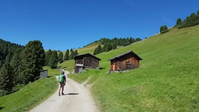 a man walking down a dirt road on a hill at Appartements Schusterhof in Naz-Sciaves