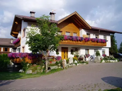 a house with flowers in front of it at Appartements Schusterhof in Naz-Sciaves
