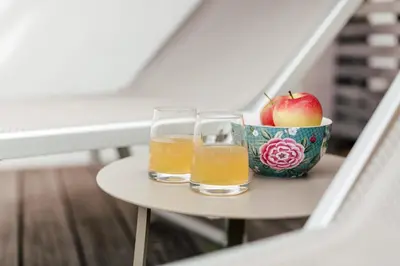 two glasses of beer and a bowl of apples on a table at Hotel Garni Sirmian in Merano