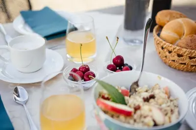 a table with a bowl of food and a bowl of fruit at Hotel Garni Sirmian in Merano