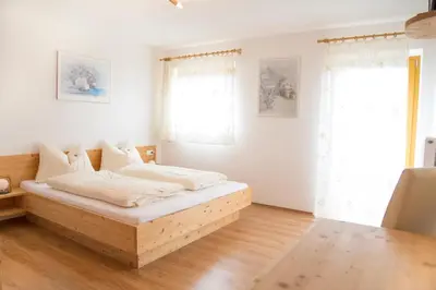 a bedroom with a wooden bed in a room at Unterer Obereggerhof in San Leonardo in Passiria