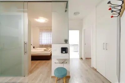 a living room with a glass door and a blue stool at Apartment Merano in Merano