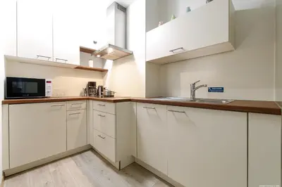 a kitchen with white cabinets and a sink at Apartment Merano in Merano