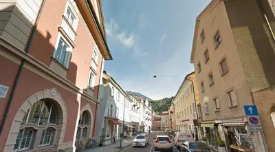a city street with buildings and cars on the road at Apartment Merano in Merano
