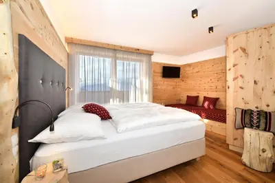 a bedroom with a large white bed in a room at Ban Rutzner in SantʼAndrea in Monte