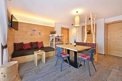 a room with a table and chairs and a couch at Ban Rutzner in SantʼAndrea in Monte