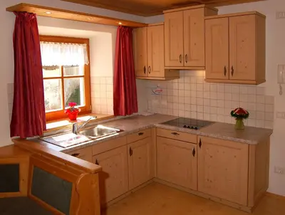a kitchen with wooden cabinets and a sink and a window at Vilahof in San Vigilio Di Marebbe