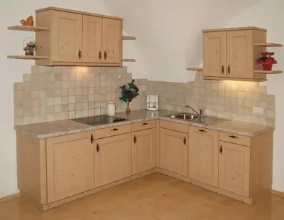 a kitchen with wooden cabinets and a sink at Vilahof in San Vigilio Di Marebbe