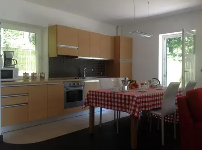 a kitchen with a table with a red and white table cloth at Chalet Villa Bianca in Tesero