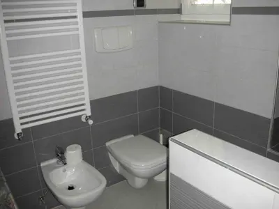 a small bathroom with a toilet and a sink at Chalet Villa Bianca in Tesero