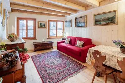 a living room with a red couch and a table at Villa Olimpia - Stayincortina in Cortina dʼAmpezzo