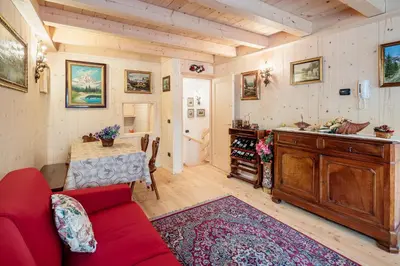 a living room with a red couch and a table at Villa Olimpia - Stayincortina in Cortina dʼAmpezzo