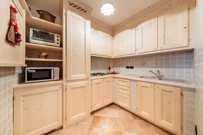 a kitchen with white cabinets and a sink at Villa Olimpia - Stayincortina in Cortina dʼAmpezzo
