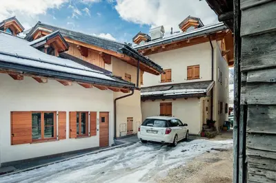 a car parked in a parking lot between two buildings at Villa Olimpia - Stayincortina in Cortina dʼAmpezzo