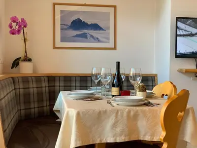 a table with plates and wine glasses on it at Apartments Ansciuda in Ortisei