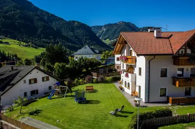 a view of a yard with a house and a playground at Apartments Ansciuda in Ortisei