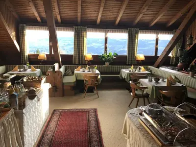 a restaurant with tables and chairs and windows at Hotel Garni Vigilhof in Lana