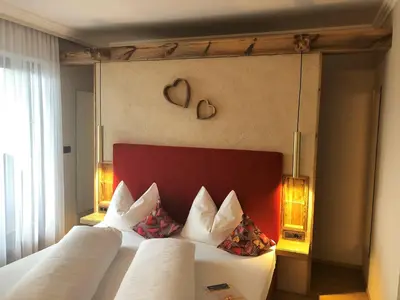 a bedroom with a bed with a red headboard at Hotel Garni Vigilhof in Lana