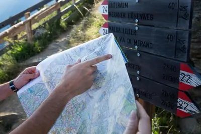 a person holding a map in front of a sign at Hotel Garni Vigilhof in Lana