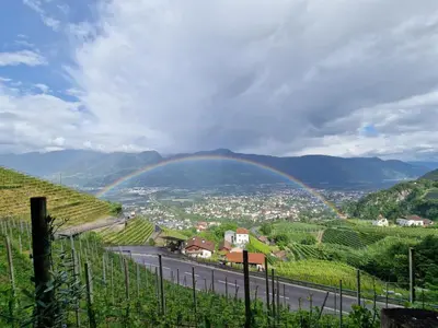 a rainbow over a valley with a town and a road at Hotel Garni Vigilhof in Lana
