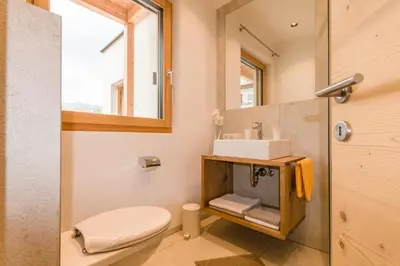 a bathroom with a toilet and a sink and a mirror at Praitladhof in Lana