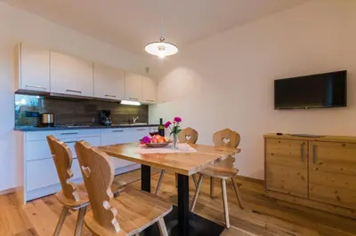 a kitchen and dining room with a wooden table and chairs at Praitladhof in Lana