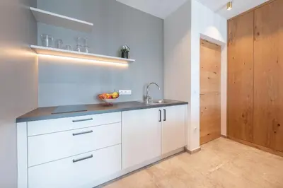 a kitchen with white cabinets and a sink at Villa Montis Exclusive Holiday Apartments in Eppan with Spectacular Views of Dolomites and Bolzano Area in Appiano sulla Strada del Vino