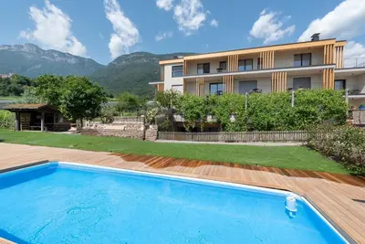 a swimming pool in front of a building at Villa Montis Exclusive Holiday Apartments in Eppan with Spectacular Views of Dolomites and Bolzano Area in Appiano sulla Strada del Vino