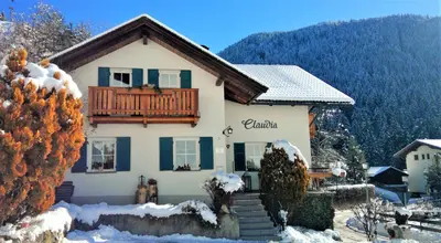 a house with a balcony in the snow at Haus Claudia B&B in Nova Levante