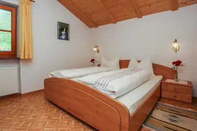 a bedroom with a wooden bed with white sheets at Malsethhof in Villandro