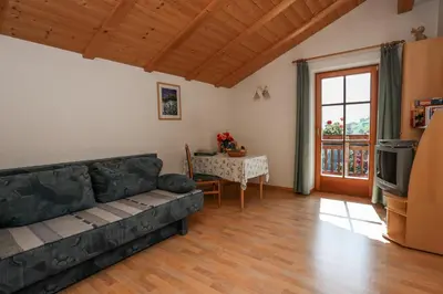 a living room with a black couch and a table at Malsethhof in Villandro