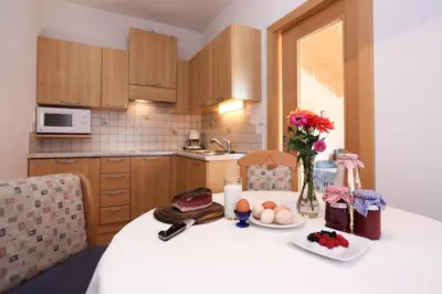 a kitchen with a table with food and flowers on it at Malsethhof in Villandro