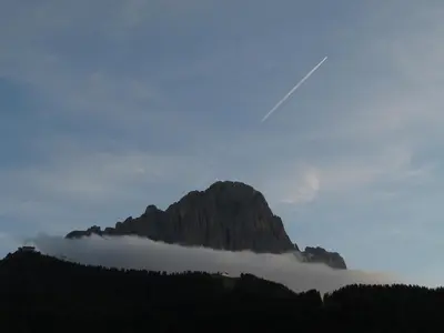 a mountain in the middle of a fog covered valley at Tinahof in Selva di Val Gardena