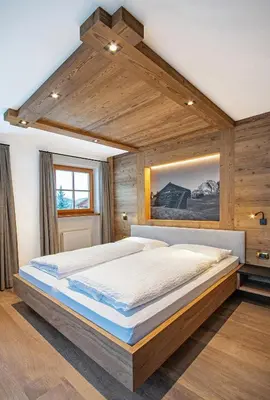 a bedroom with a large bed in a room at Tinahof in Selva di Val Gardena