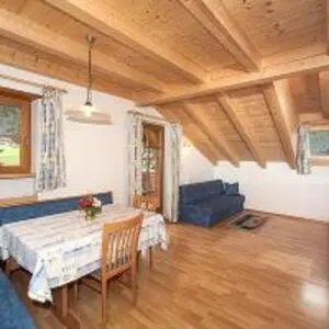 a living room with a table and a blue couch at Tinahof in Selva di Val Gardena