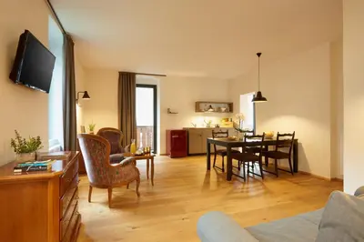 a dining room and living room with a dining table at Historic Guesthouse BIRCHER B&B Apartments near Sterzing in Campo di Trens