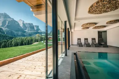 a house with a swimming pool and a view of mountains at Lüch de Costa in Colfosco