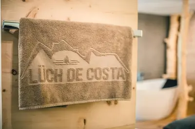 a towel hanging on the wall of a bathroom at Lüch de Costa in Colfosco