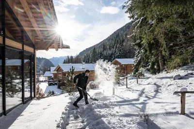 a man walking through the snow with skis at Valsegg Chalets Südtirol - luxury and private hideaway in Valles