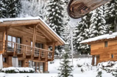 a snowfall is coming out of a wooden house at Valsegg Chalets Südtirol - luxury and private hideaway in Valles