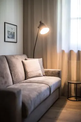a living room with a couch and a lamp at Landhaus Lina in Caldaro