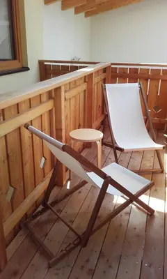 a chair and a table in a room at Ferienhof Weingenuss in Cortina Sulla Strada Del Vino