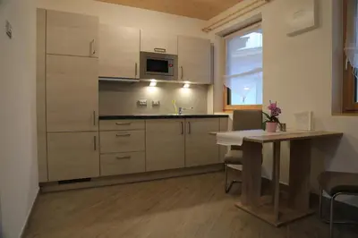 a kitchen with white cabinets and a table and a window at Ferienhof Weingenuss in Cortina Sulla Strada Del Vino